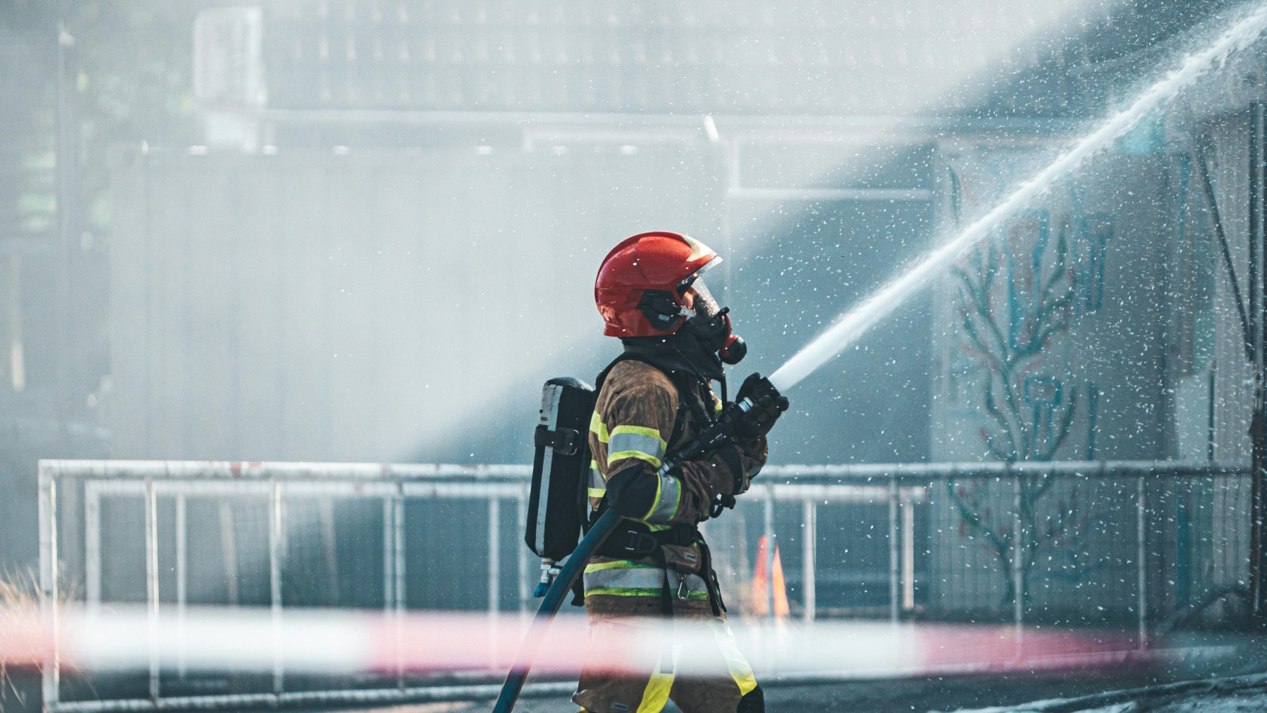 firefighter using an air atomizing spray nozzle for fire suppression